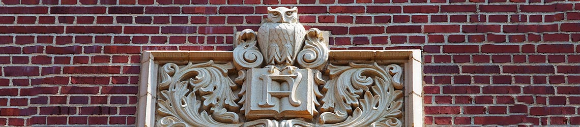 Photo of a stonework owl and book emblem on the outside Eppes Hall l